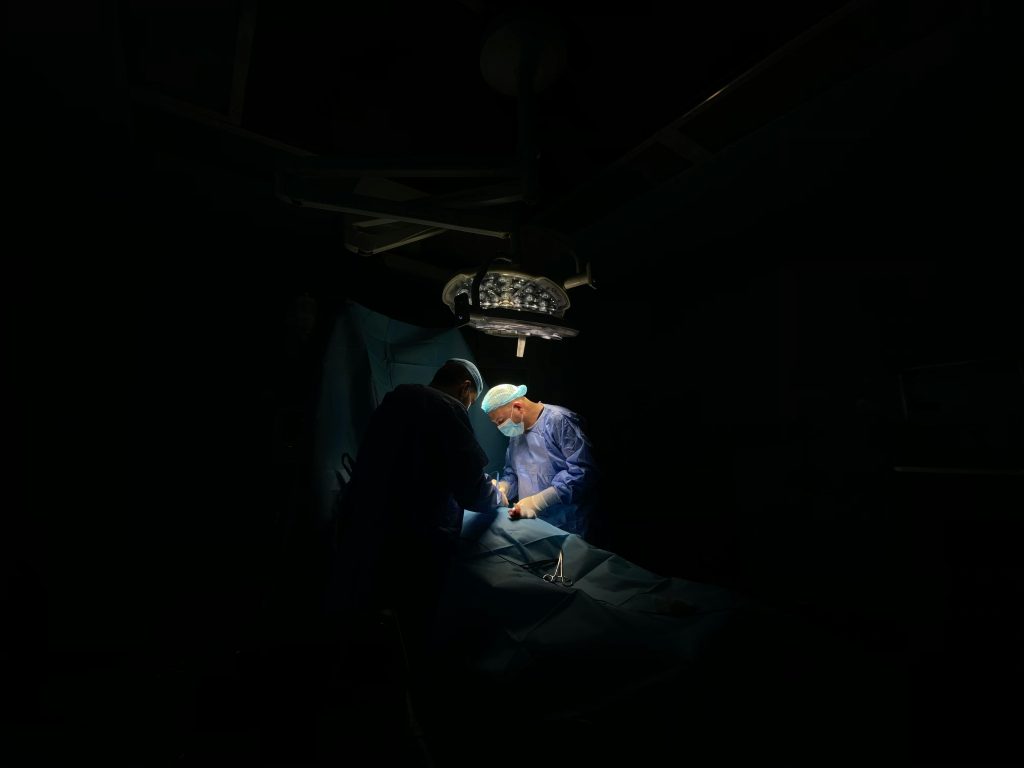 pexels-photo-10949052-10949052 Two surgeons focus intently on a medical operation under surgical lights.