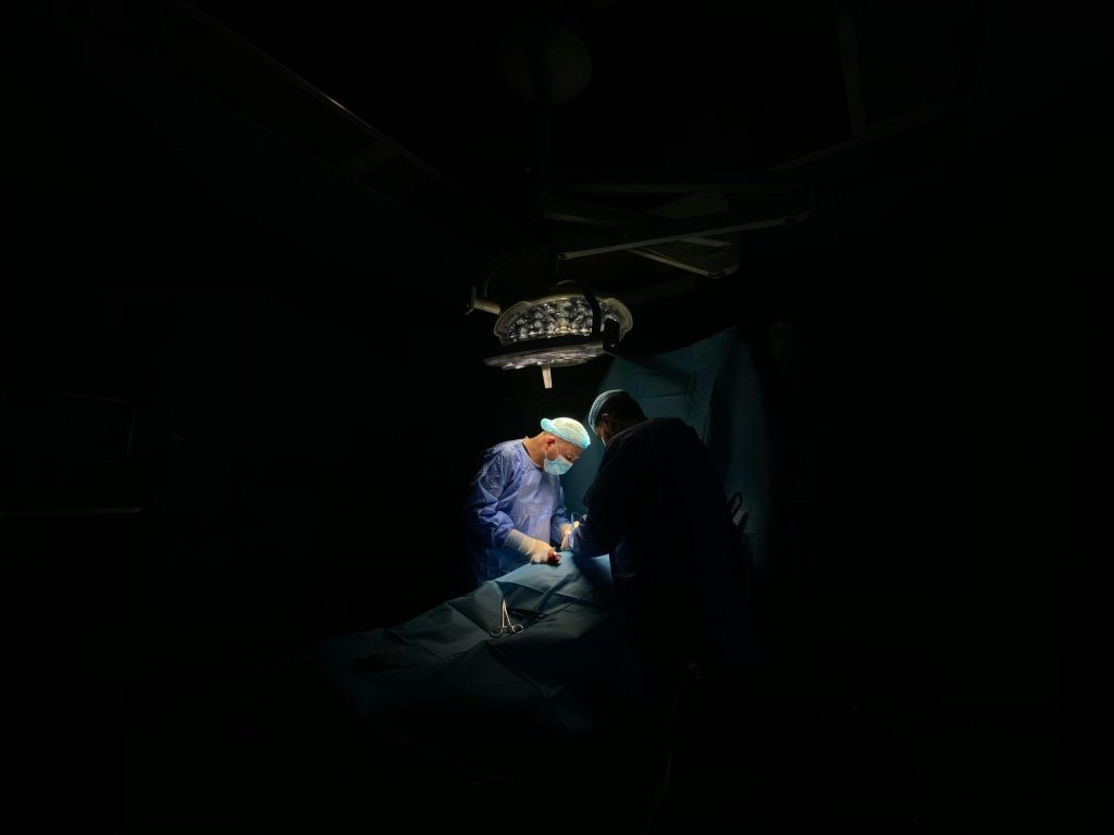 pexels-photo-10949052-10949052 Two surgeons focus intently on a medical operation under surgical lights.